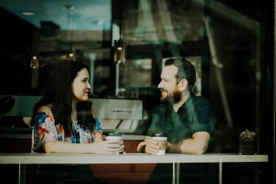 conflict resolution - man woman talking over coffee in cafe