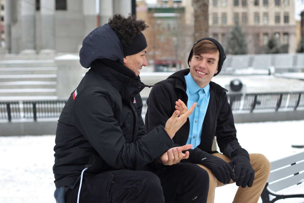 2 men talking on a bench