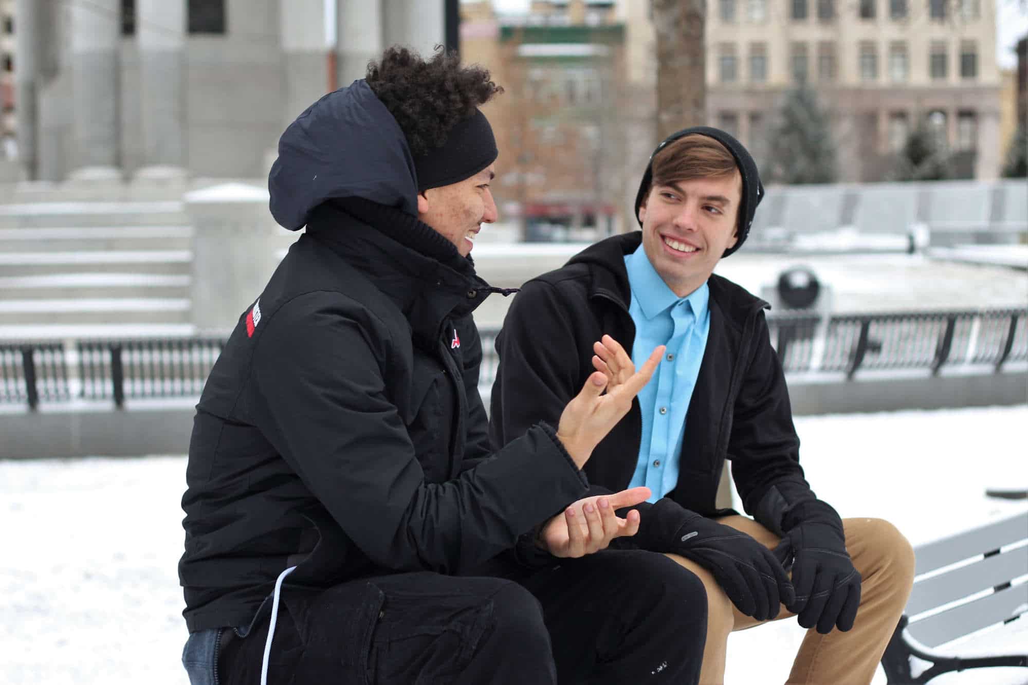 2 men talking on a bench