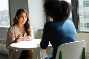 conflict resolution skills - two ladies talking at a table