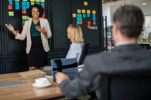 conflict resolution skills - people talking in meeting, woman presenting